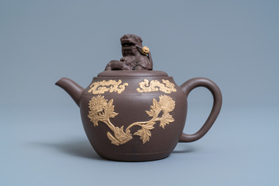 A bichrome Chinese Yixing stoneware teapot and cover with applied floral design, Kangxi