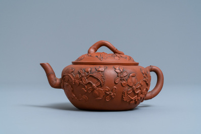 Een Chinese Yixing steengoed theepot met opgelegd floraal decor, Kangxi