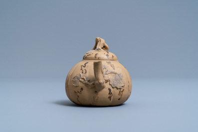 A bichrome Chinese Yixing stoneware teapot and cover with applied floral design, 19th C.