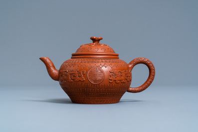 A Chinese Yixing stoneware teapot and cover with applied and impressed design, Kangxi