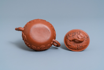 A Chinese Yixing stoneware teapot and cover with applied floral design, Kangxi