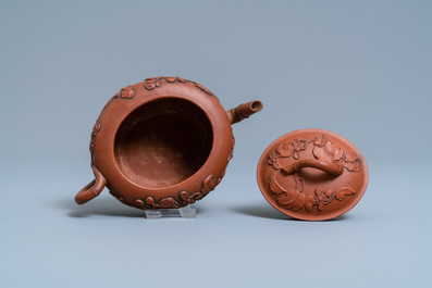 A Chinese Yixing stoneware teapot and cover with applied floral design, Kangxi