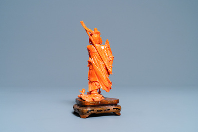 A Chinese carved red coral figure of a warrior holding a flag, 19/20th C.