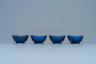 Four Chinese gilt-decorated blue-ground cups and saucers with fine landscapes, Qianlong