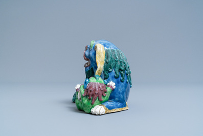 A Chinese porcelain 'Buddhist lion and cub' group on carved wooden stand, 19th C.