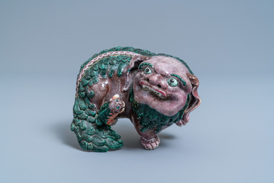 A Chinese porcelain 'Buddhist lion and cub' group on carved wooden stand, 19th C.