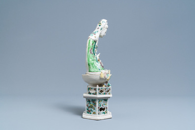 Een Chinese verte biscuit figuur van Guanyin op lotustroon, Kangxi