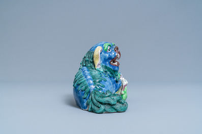 Un groupe en porcelaine de Chine figurant un lion bouddhiste et son lionceau sur socle en bois, 19&egrave;me