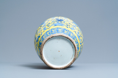 A Chinese blue and white yellow-ground vase with floral design, 19th C.