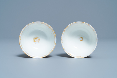 A pair of Chinese gilded famille rose 'Mongolian hunt' cups and saucers, Qianlong