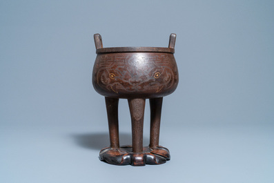 A Chinese inlaid bronze tripod censer on wooden stand, Ming