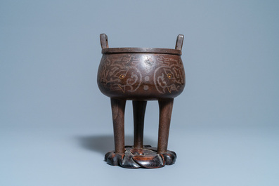 A Chinese inlaid bronze tripod censer on wooden stand, Ming