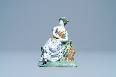 A polychrome Dutch Delft figure of a seated lady, 18th C.