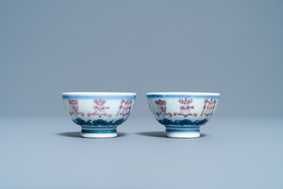 A pair of Chinese blue, white and copper red 'bajixiang' tea bowls, 4-character mark, 19/20th C.