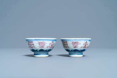 A pair of Chinese blue, white and copper red 'bajixiang' tea bowls, 4-character mark, 19/20th C.