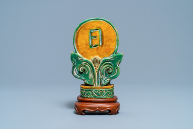 A Chinese sancai-glazed Buddhist emblem on wooden stand, Ming