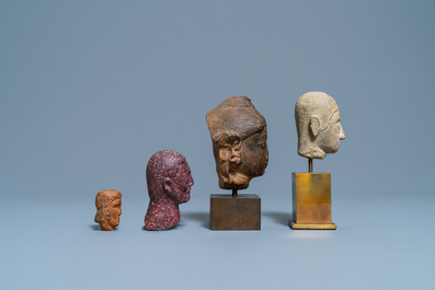 Vier diverse gesculpteerde stenen koppen, 17e eeuw en later