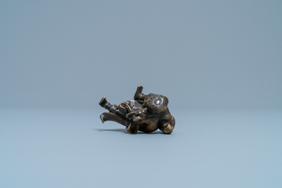 A Chinese bronze 'Liu Hai' scroll weight on wooden stand, Ming