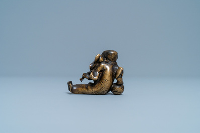 Een Chinees bronzen 'Liu Hai' scrollgewicht op houten sokkel, Ming