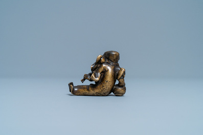 A Chinese bronze 'Liu Hai' scroll weight on wooden stand, Ming