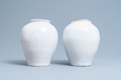 A pair of Dutch Delft blue and white tobacco jars with a trader, 18th C.