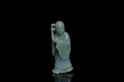Een Chinese figuur van een onsterfelijke in celadon jade op houten sokkel, Qing