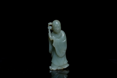 A Chinese carved celadon jade 'immortal' figure on wooden stand, Qing