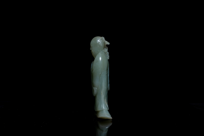 A Chinese carved celadon jade 'immortal' figure on wooden stand, Qing