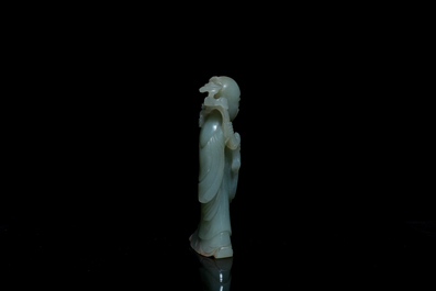 A Chinese carved celadon jade 'immortal' figure on wooden stand, Qing