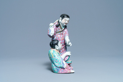 Un groupe en porcelaine de Chine famille rose figurant deux gar&ccedil;ons avec une chauve-souris, marque en creux, R&eacute;publique