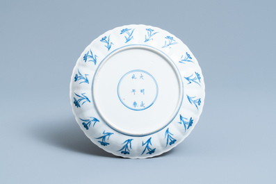 Een Chinees blauw-wit bord met erotisch decor, Chenghua merk, Kangxi
