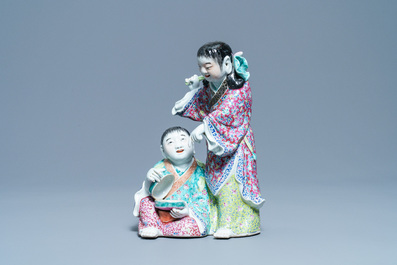Un groupe en porcelaine de Chine famille rose figurant deux gar&ccedil;ons avec une chauve-souris, marque en creux, R&eacute;publique