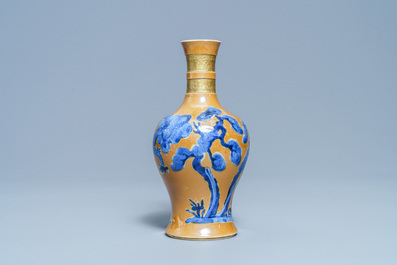 Un vase en porcelaine de Chine en bleu et blanc sur fond caf&eacute; au lait, Kangxi