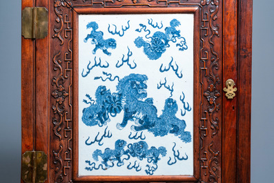 Een Chinese hongmu houten kast met een blauw-witte 'boeddhistische leeuwen' plaquette, 19e eeuw