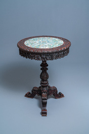 A Chinese carved wooden table with a large Canton famille verte plaque, 19th C.