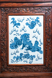 Een Chinese hongmu houten kast met een blauw-witte 'boeddhistische leeuwen' plaquette, 19e eeuw