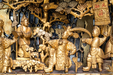 A Chinese gilded wood carving on matching pillars, 19th C.