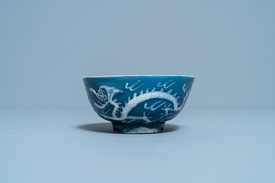 Een Chinese 'drakenkom' met wit slipglazuur op blauwe fondkleur, Yu Tang Jia Qi merk, Wanli
