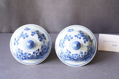 A pair of Chinese blue and white baluster vases and covers with birds in a rocky landscape, Kangxi