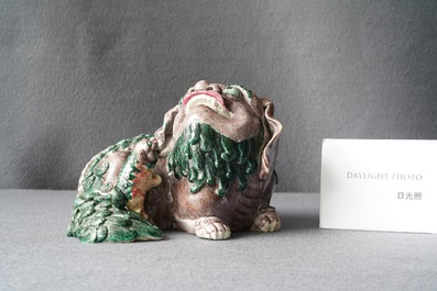 Un groupe en porcelaine de Chine figurant un lion bouddhiste et son lionceau sur socle en bois, 19&egrave;me