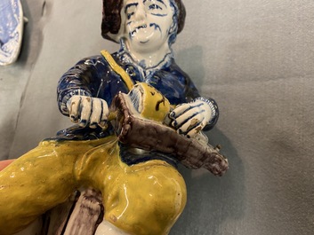 A polychrome Dutch Delft figure of a hurdy-gurdy player, 18th C.