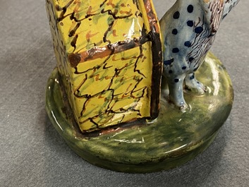 A polychrome Dutch Delft model of a dog by its doghouse, 18th C.
