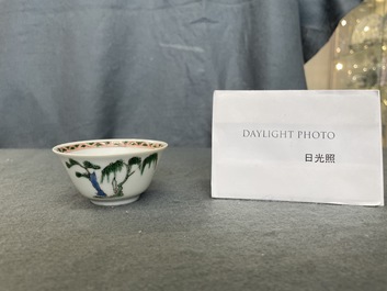 A Chinese famille verte 'erotical subject' cup and saucer, Kangxi