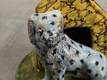 A polychrome Dutch Delft model of a dog by its doghouse, 18th C.