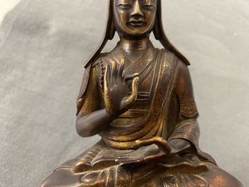 Een Sino-Tibetaanse vergulde bronzen figuur van een lama, 18/19e eeuw