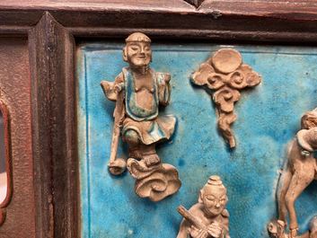 A Chinese square fahua 'Immortals' plaque mounted in a wooden table screen, Ming