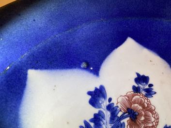 Un plat en porcelaine de Chine en bleu, blanc et rouge de cuivre sur fond bleu poudr&eacute;, Kangxi