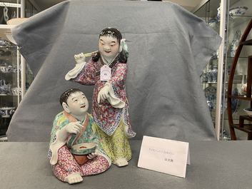 Un groupe en porcelaine de Chine famille rose figurant deux gar&ccedil;ons avec une chauve-souris, marque en creux, R&eacute;publique