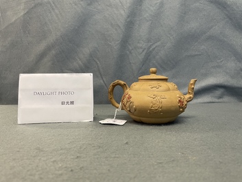 A bichrome Chinese Yixing stoneware teapot and cover with applied design, Kangxi