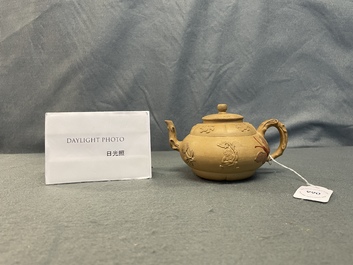 A bichrome Chinese Yixing stoneware teapot and cover with applied design, Kangxi